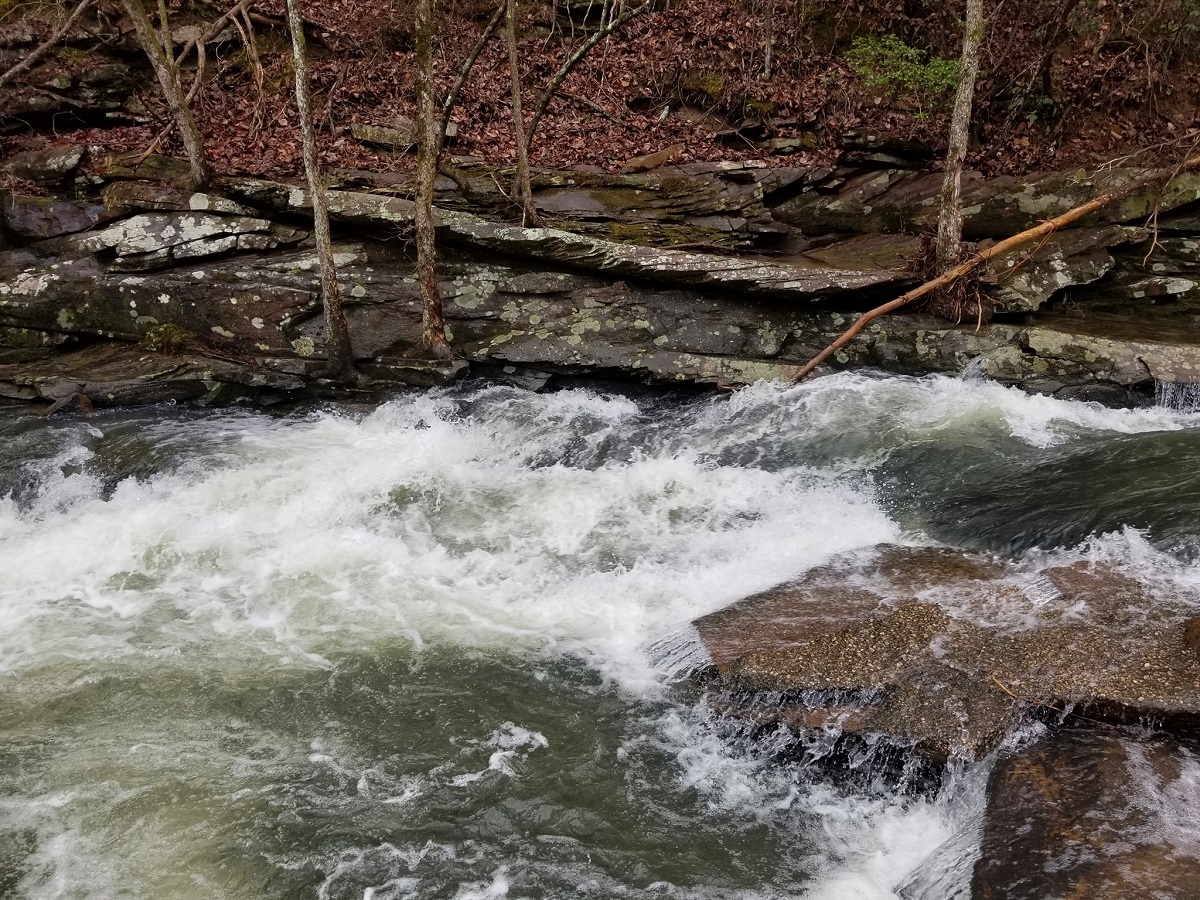 The first drop, about 25 yards below the bridge. Note the thin film of water coming over the rock on river left. This is the lowest acceptable level, where the upper section is scrapey but OK, the steep section is good, and the runout is terrible.