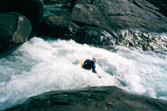 Marshall Fox looking down the barrel of the last drop on Pinball. The rock on river left just upstream of him is rather undercut.